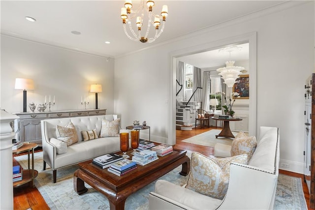 living room featuring hardwood / wood-style flooring, crown molding, and an inviting chandelier