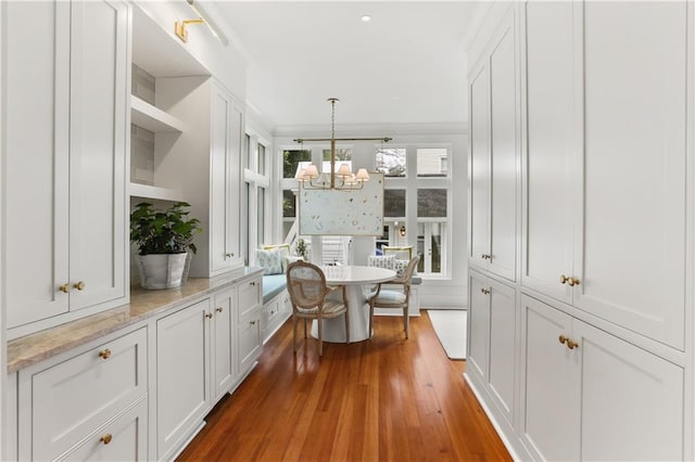 interior space with crown molding, wood-type flooring, and a notable chandelier