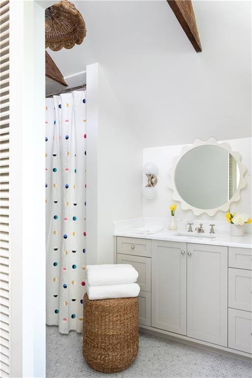 bathroom featuring vanity, beam ceiling, and walk in shower