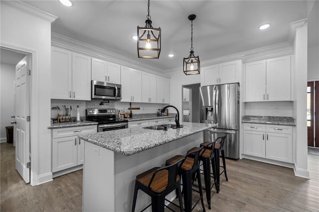 kitchen with sink, white cabinetry, a kitchen island with sink, stainless steel appliances, and light stone counters