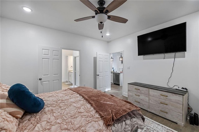 bedroom featuring ceiling fan, ensuite bath, and light hardwood / wood-style flooring