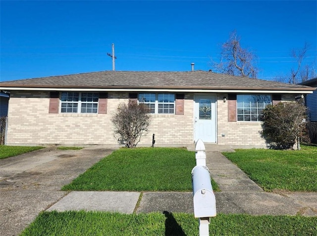 ranch-style house featuring brick siding, roof with shingles, and a front yard