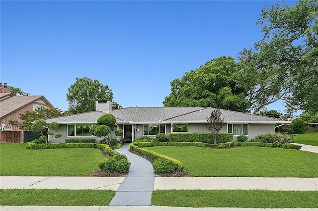 ranch-style home featuring a front lawn and a chimney