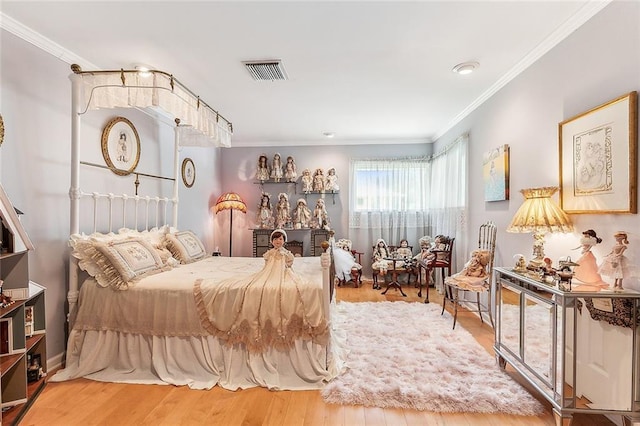 bedroom featuring visible vents, wood finished floors, and crown molding