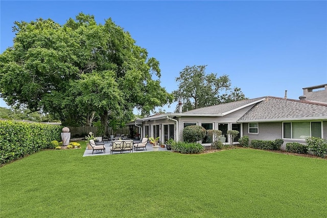 rear view of house featuring a patio, a lawn, and fence