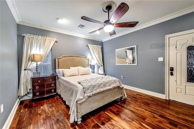 bedroom featuring visible vents, crown molding, and wood finished floors