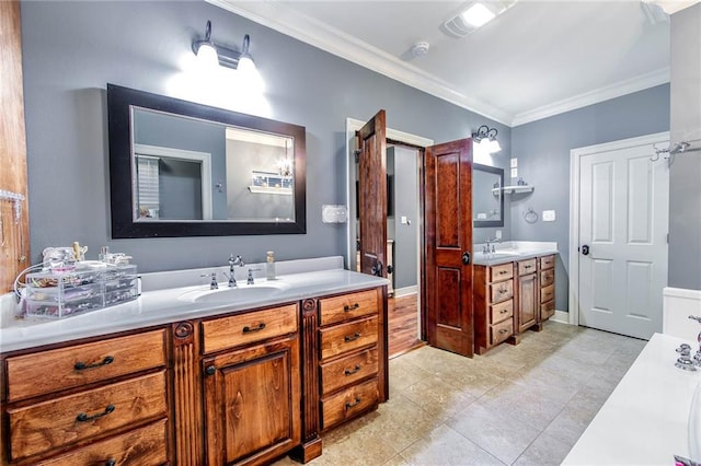 full bath with ornamental molding, two vanities, a sink, and baseboards