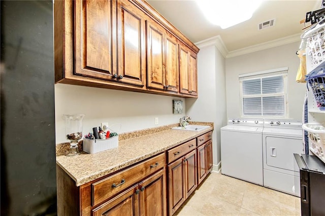 laundry room with cabinet space, visible vents, crown molding, separate washer and dryer, and a sink