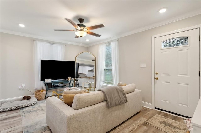 living area with light wood finished floors, baseboards, a ceiling fan, crown molding, and recessed lighting