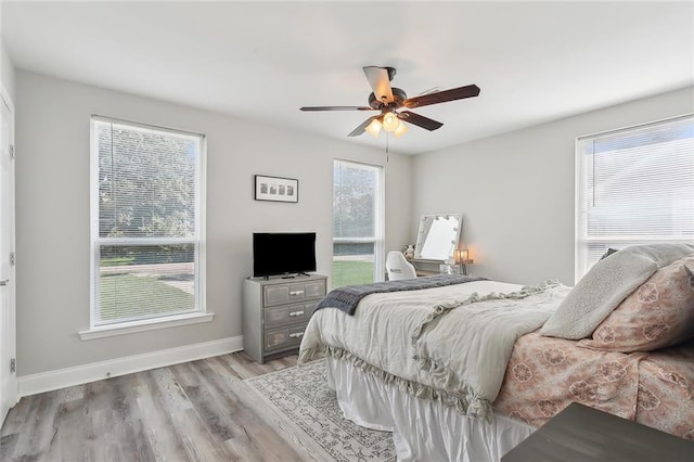 bedroom featuring ceiling fan, baseboards, and wood finished floors