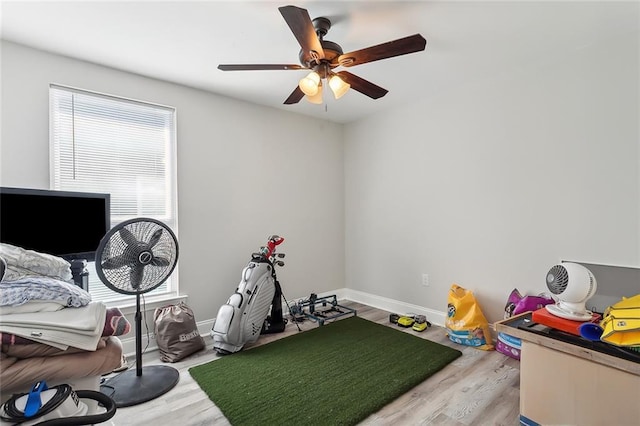 game room featuring baseboards, ceiling fan, and light wood finished floors