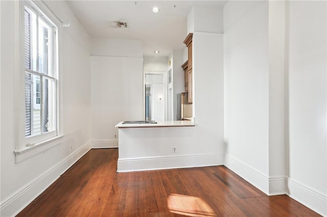 unfurnished room featuring dark hardwood / wood-style flooring and a wealth of natural light