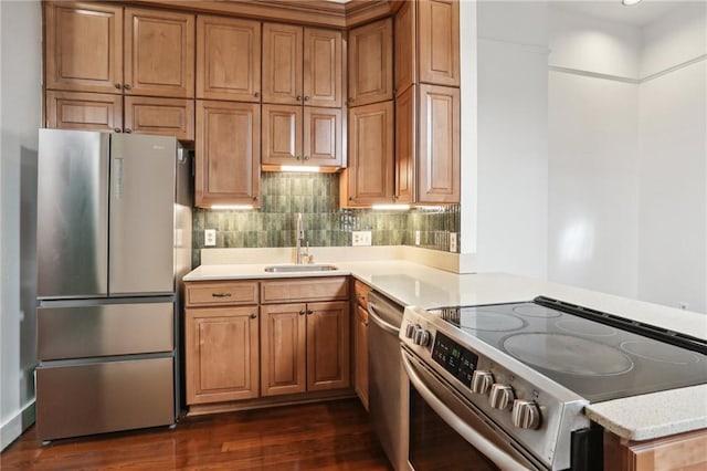 kitchen with sink, stainless steel appliances, light stone countertops, dark hardwood / wood-style flooring, and decorative backsplash