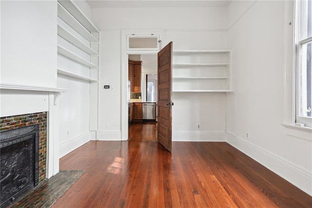 unfurnished living room with a tiled fireplace and dark hardwood / wood-style flooring