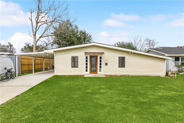 rear view of property with a carport and a lawn