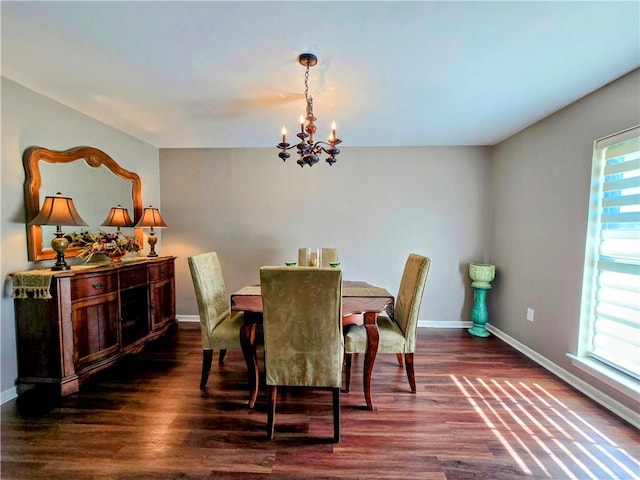 dining space featuring an inviting chandelier, plenty of natural light, and dark hardwood / wood-style floors