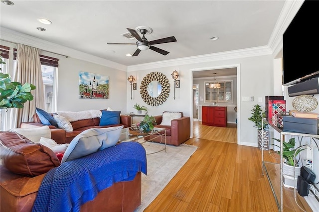 living room with sink, crown molding, light hardwood / wood-style floors, and ceiling fan