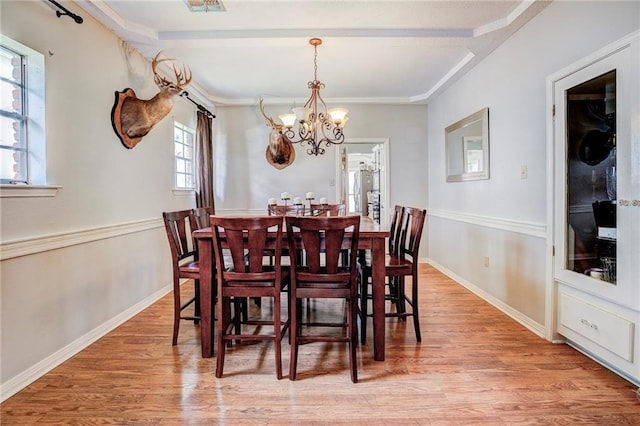 dining space featuring hardwood / wood-style flooring and a notable chandelier