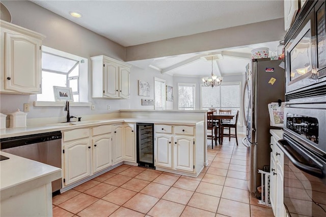 kitchen with pendant lighting, sink, light tile patterned floors, stainless steel appliances, and beverage cooler