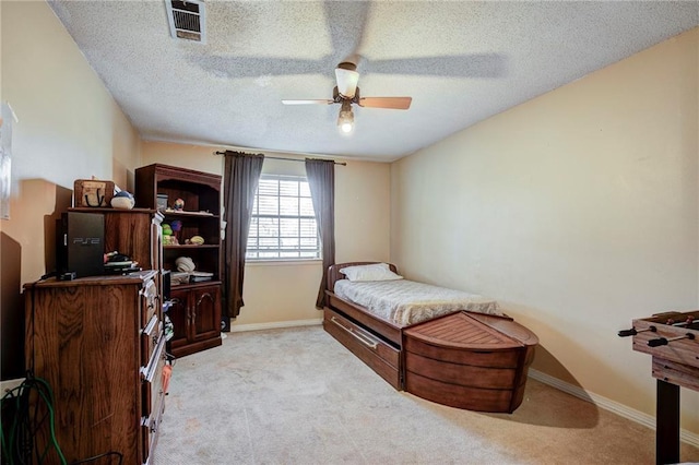 carpeted bedroom with ceiling fan and a textured ceiling