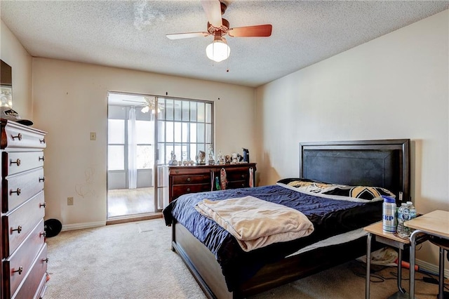 bedroom featuring ceiling fan, light colored carpet, and a textured ceiling