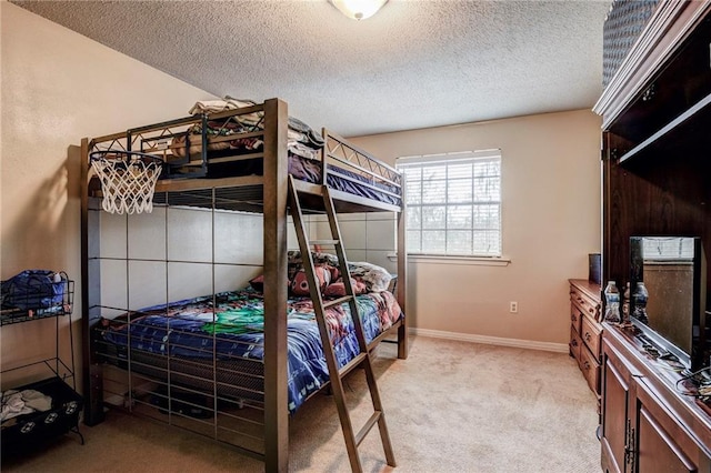 bedroom with light colored carpet and a textured ceiling