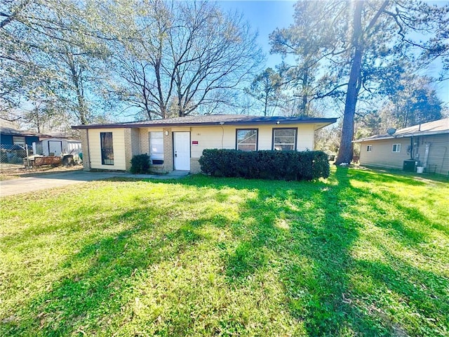 ranch-style home with central AC unit and a front lawn