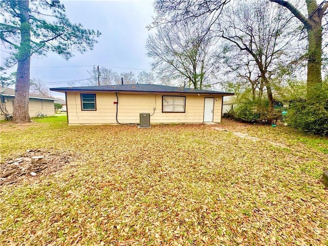 back of house with a yard and central air condition unit