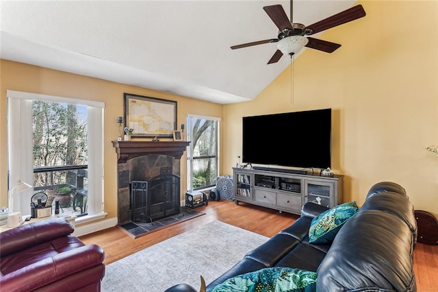 living room with lofted ceiling, hardwood / wood-style flooring, a fireplace, and ceiling fan