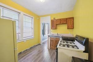 2226 Saint Bernard Ave, New Orleans, LA 70119 - kitchen featuring white gas stove, brown cabinets, and wood finished floors