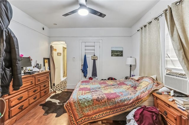 2226 Saint Bernard Ave, New Orleans, LA 70119 - bedroom with wood finished floors, arched walkways, ceiling fan, cooling unit, and a closet