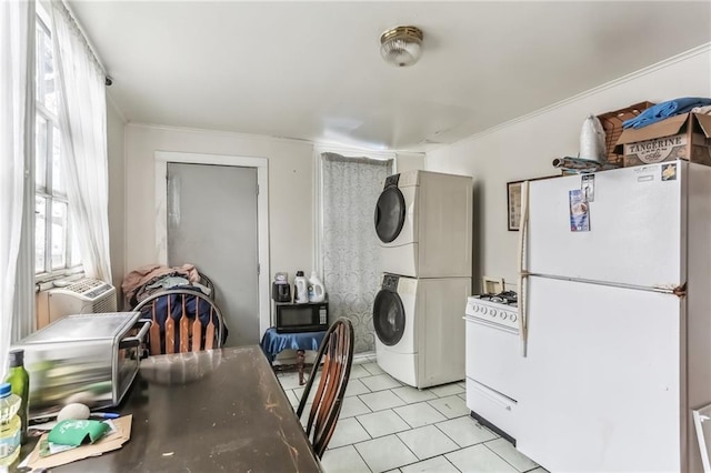 2226 Saint Bernard Ave, New Orleans, LA 70119 - kitchen featuring white appliances, stacked washing machine and dryer, light tile patterned floors, and crown molding