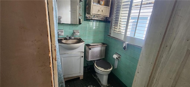 bathroom with vanity, tile walls, and toilet