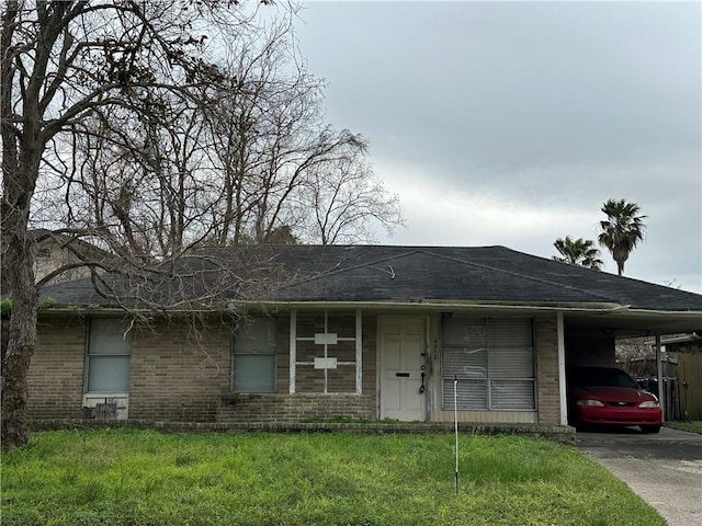 ranch-style home featuring a carport and a front lawn