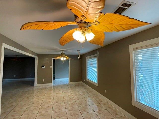 tiled empty room with ceiling fan