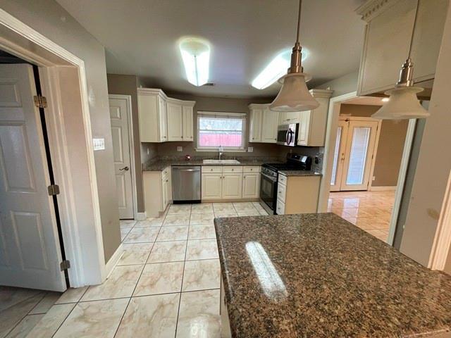 kitchen featuring stainless steel appliances, pendant lighting, sink, and light tile patterned floors