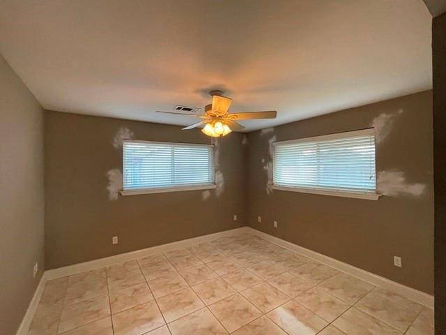 spare room featuring light tile patterned floors and ceiling fan