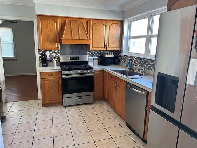 kitchen with light tile patterned flooring, sink, stainless steel appliances, and wall chimney exhaust hood