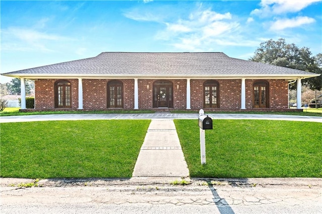 ranch-style home featuring a front yard, covered porch, and french doors