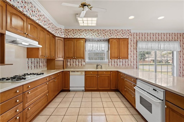 kitchen featuring crown molding, sink, white appliances, and light tile patterned floors