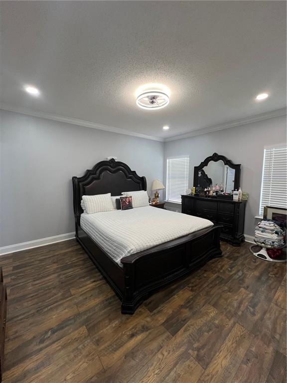 bedroom featuring dark hardwood / wood-style flooring, crown molding, and a textured ceiling