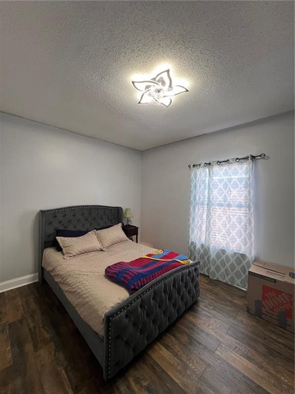 bedroom with dark hardwood / wood-style flooring and a textured ceiling