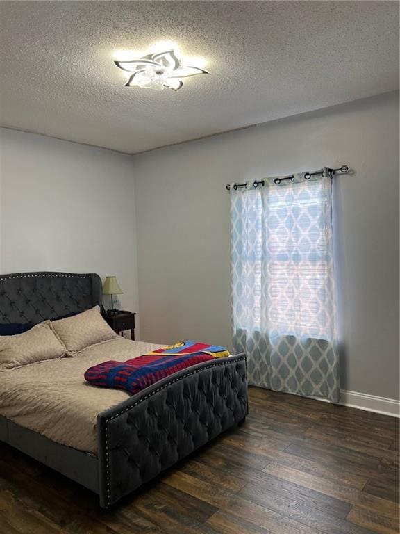 bedroom with dark wood-type flooring and a textured ceiling