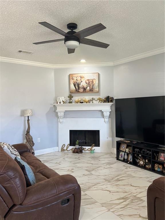 living room with ceiling fan, ornamental molding, and a textured ceiling