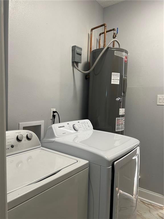 laundry room featuring electric water heater and washer and dryer