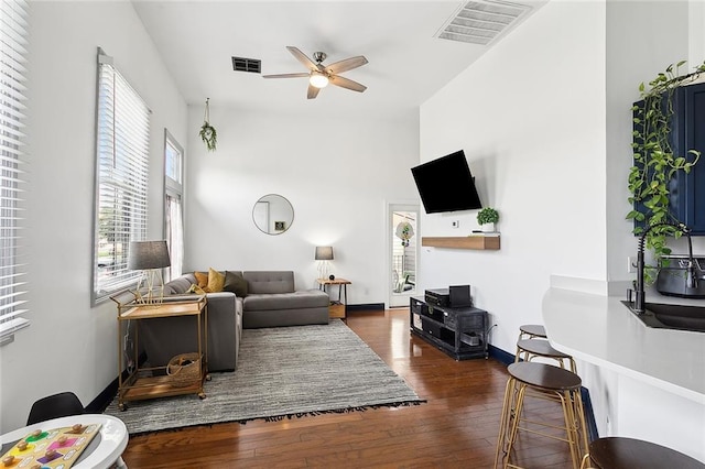 living room with a high ceiling, dark hardwood / wood-style floors, and ceiling fan