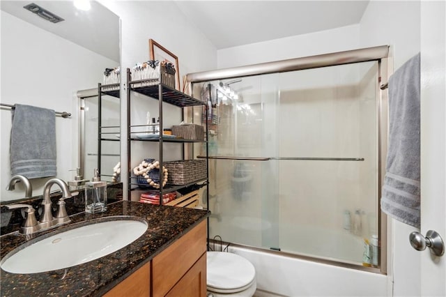 full bathroom featuring shower / bath combination with glass door, vanity, and toilet