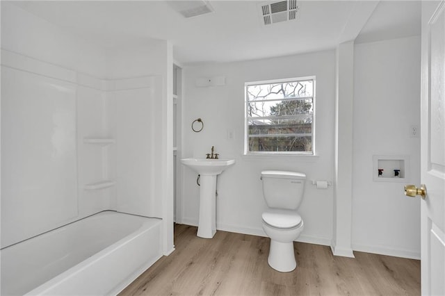 bathroom featuring hardwood / wood-style floors,  shower combination, and toilet