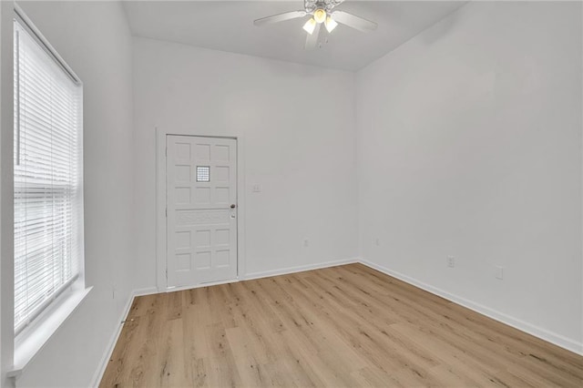 empty room featuring ceiling fan, light wood-type flooring, and a healthy amount of sunlight