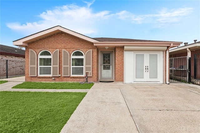 ranch-style house with a front yard and french doors